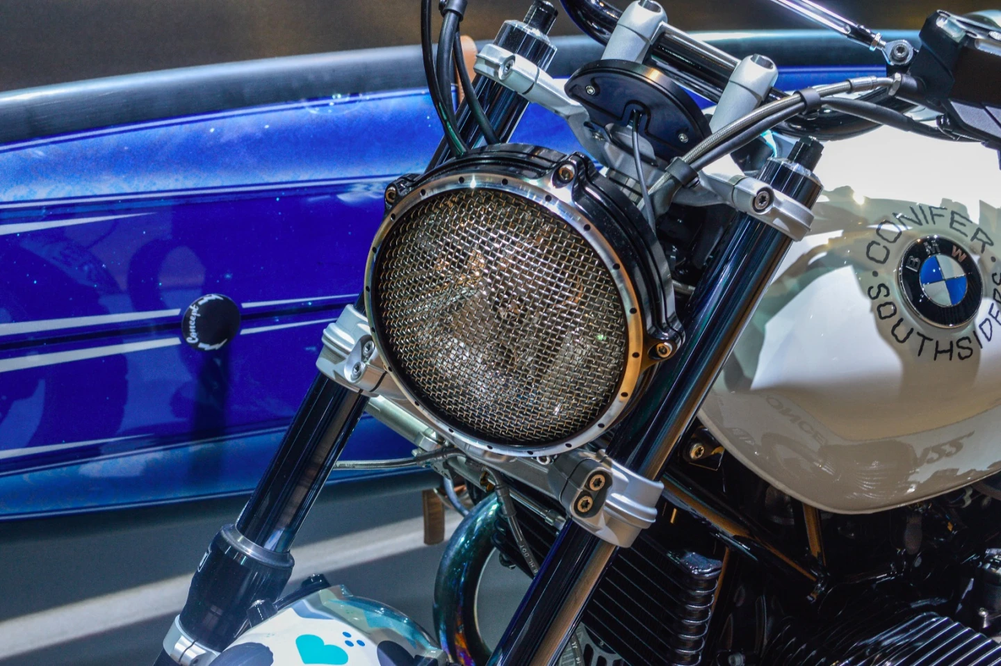 A metal mesh protects the headlight's glass from loose branches of flying debris when riding off-road