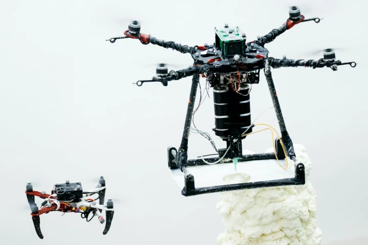 A job-supervising ScanDrone (left) alongside a 3D-printing BuilDrone (right)