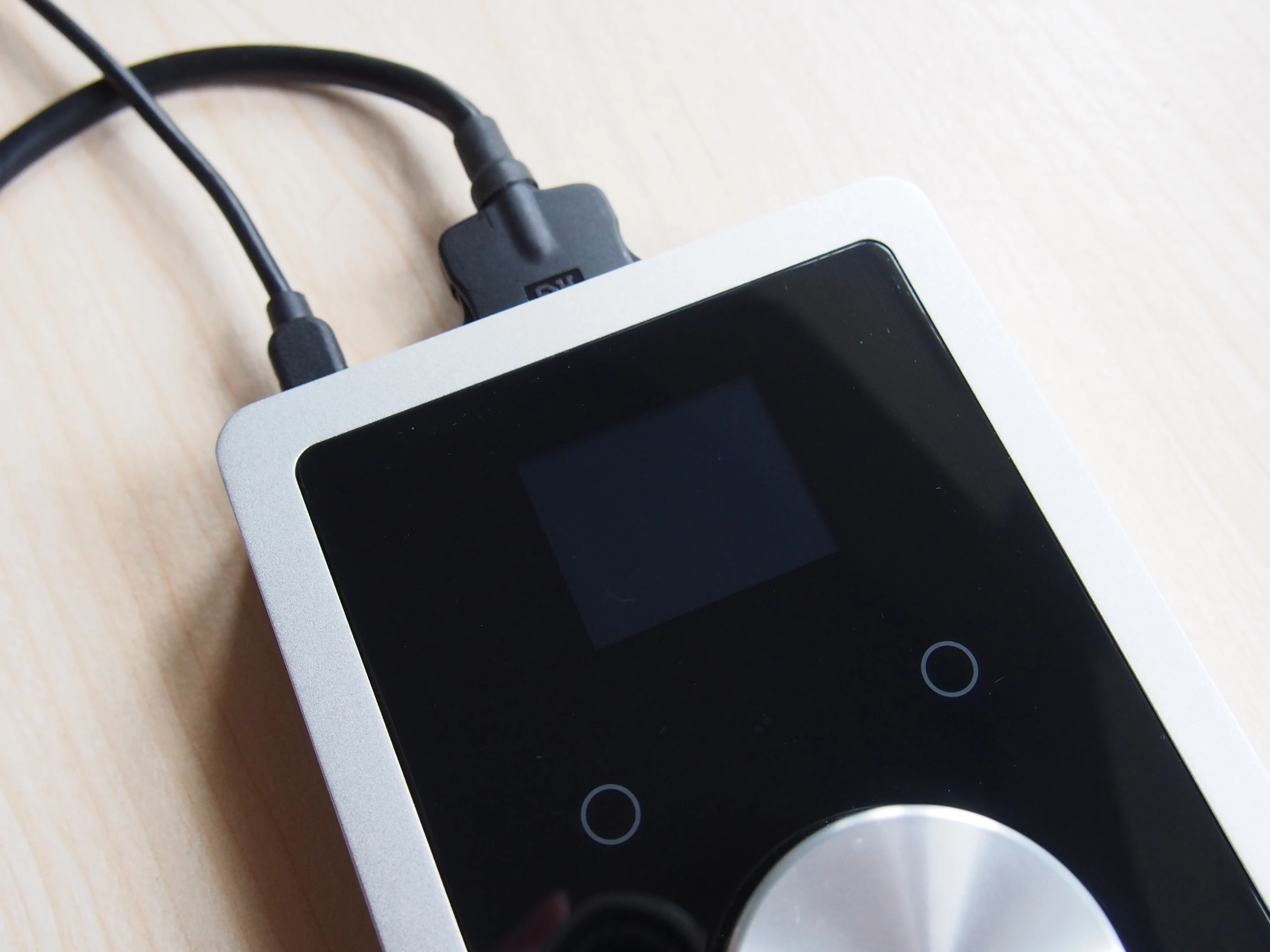 The OLED display on the top panel shows information such as output and input levels