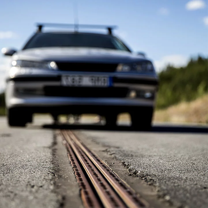 The Swedish project eRoadArlanda powers electric vehicles through a slot car-like track embedded in the road