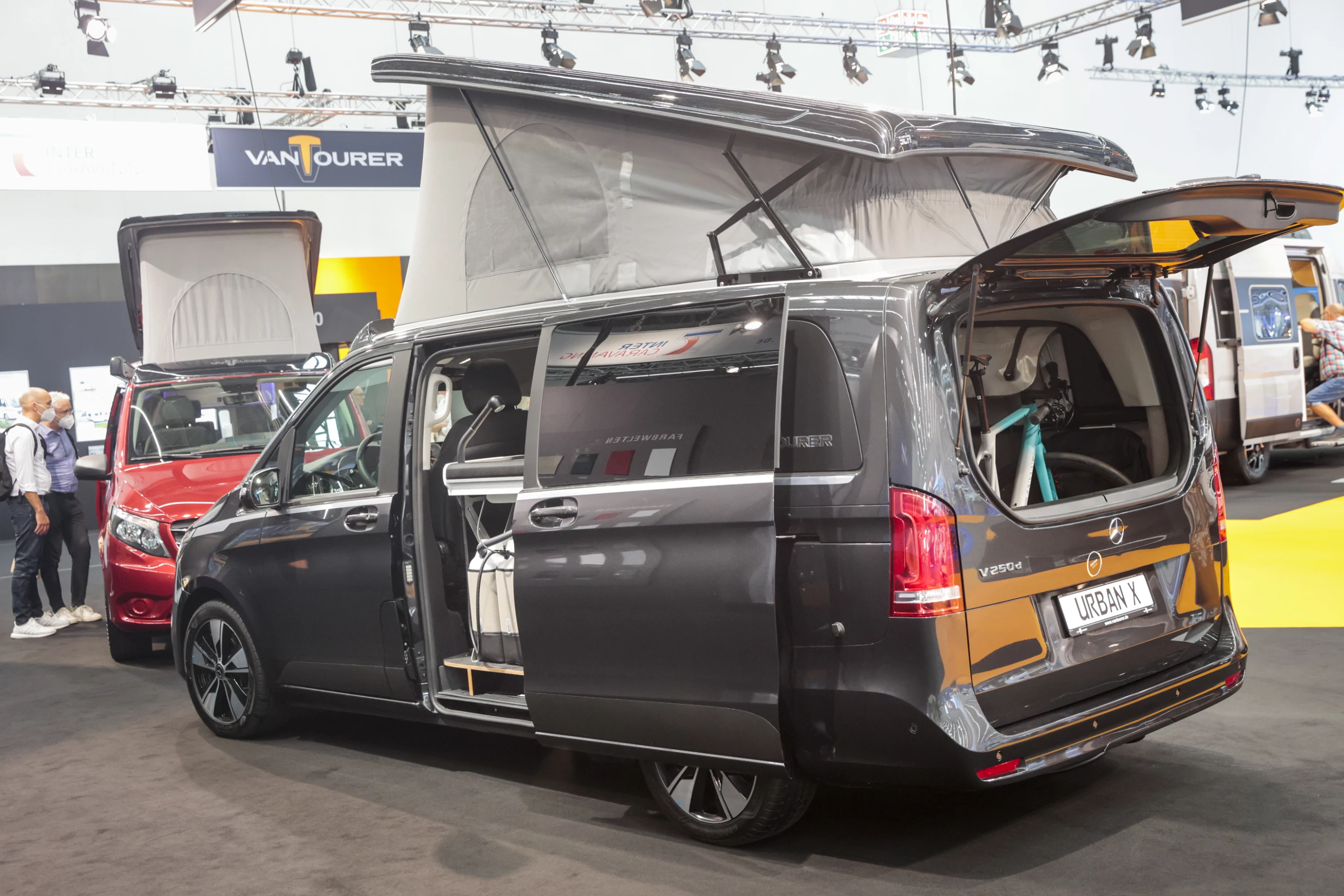 VanTourer's all-new Urban X cozies up next to a bright-red Urban model; both are based on Mercedes-Benz vans