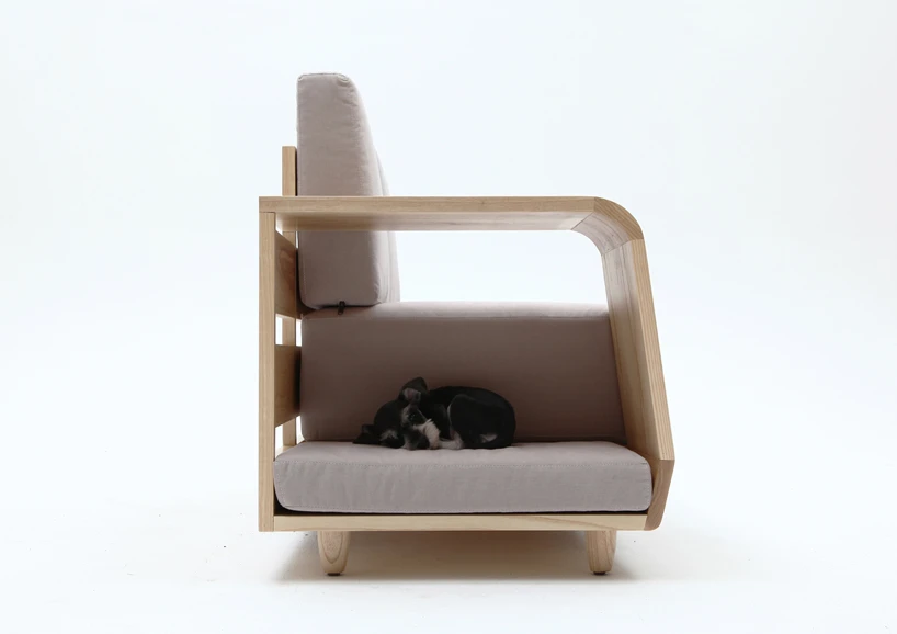 The unique dog house is positioned slightly lower than the seating area of the sofa