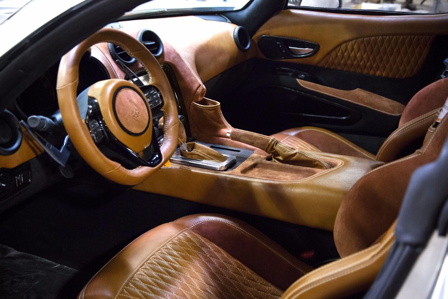 The interior features hand-stitched leather, Alcantara and suede
