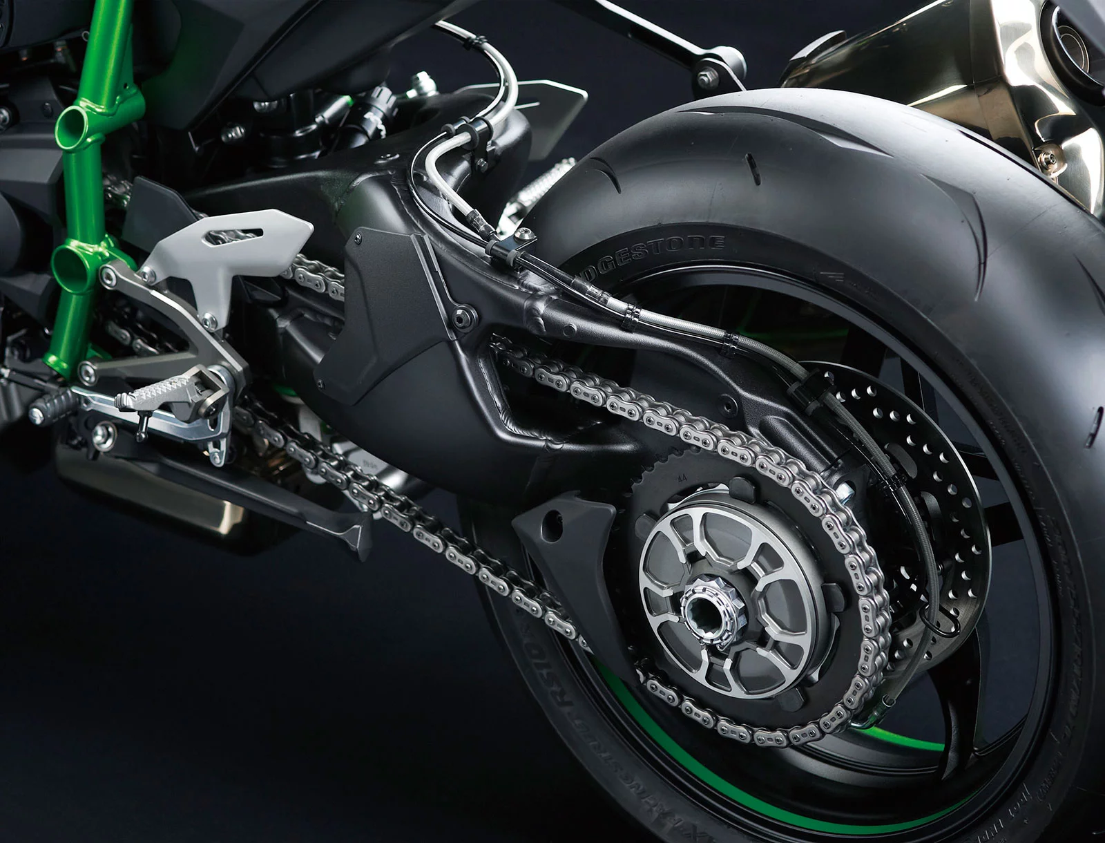 The Ninja H2 features Kawasaki’s first single-sided swingarm. Having a single-sided swingarm allows the exhaust silencer to be mounted closer to the bike centerline, ensuring a high bank angle for sporty cornering. The Swingarm Mounting Plate, an innovative new chassis mechanism, bolts to the back of the engine. The swingarm pivot shaft goes through this plate, essentially allowing the swingarm to be mounted directly to the engine. Thanks to the Swingarm Mounting Plate, the frame does not need to use cross members for stability, contributing to the frame’s light weight.