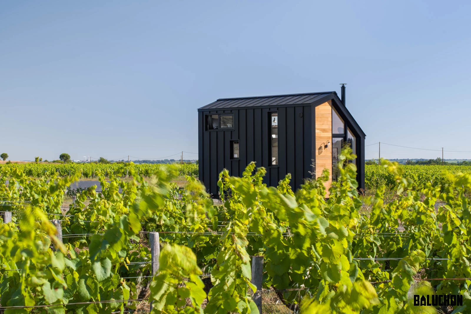 The Tiny House Sauvage is finished in red cedar, with black aluminum accenting