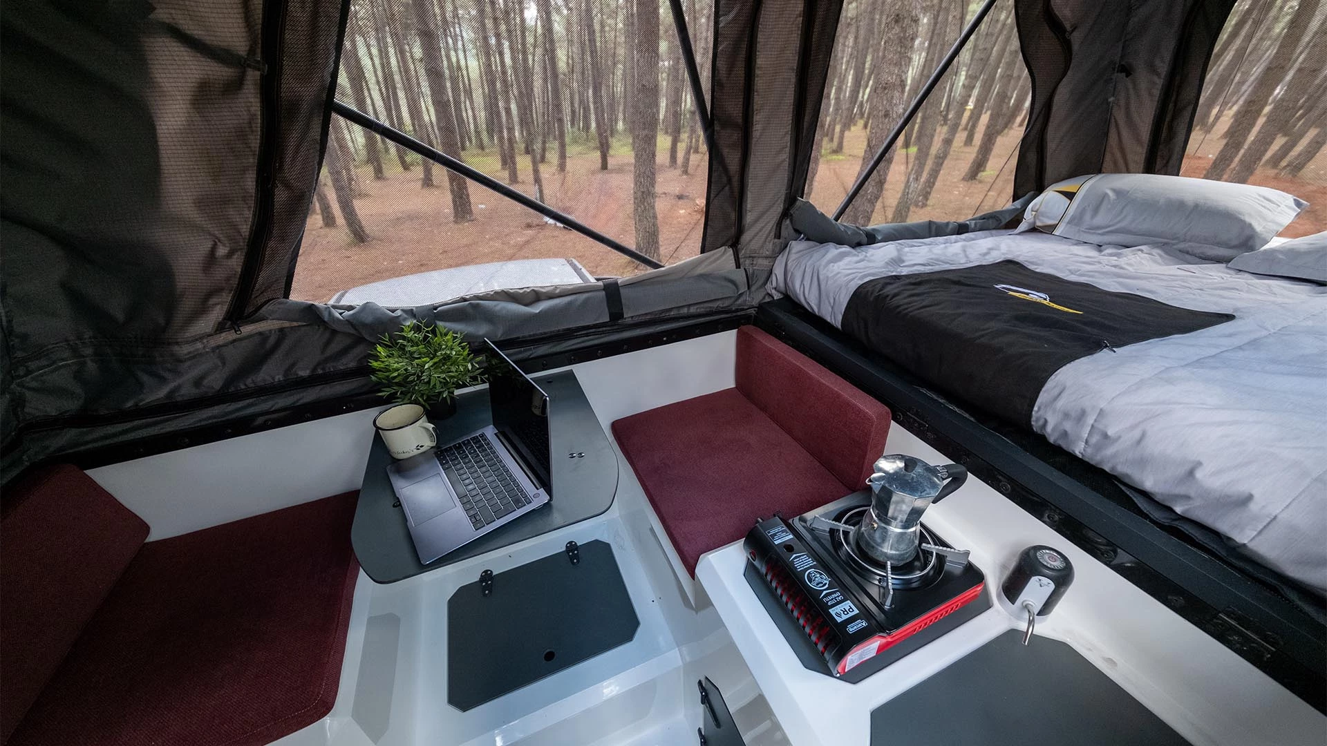 The bed retracts during the day to clear the two-seat dinette and compact kitchen area