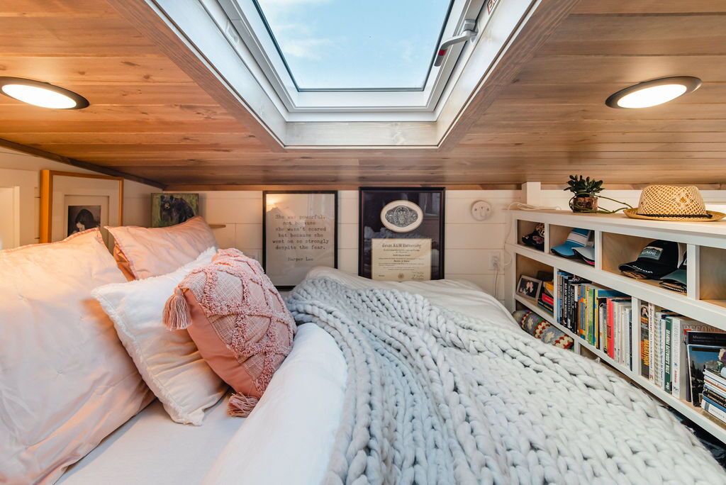 Main bedroom in Jen's 34' x 10' Tiny Home with skylights and king size bed plus some storage space