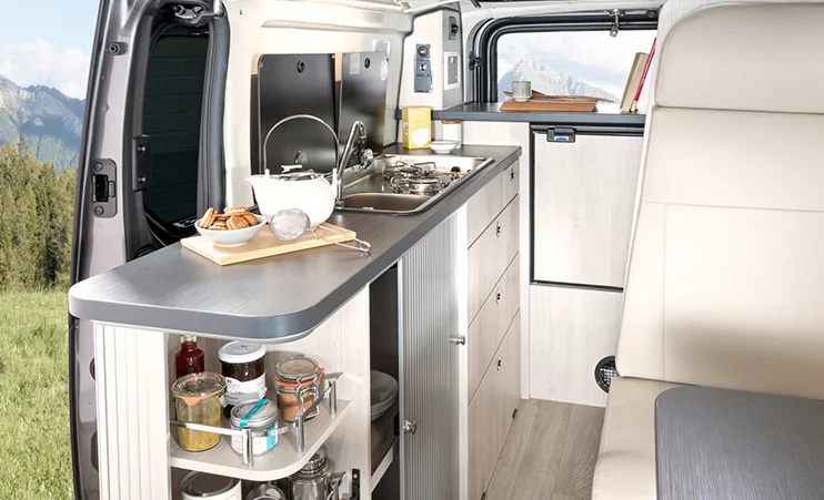 The kitchen block includes a stove, sink and plenty of storage