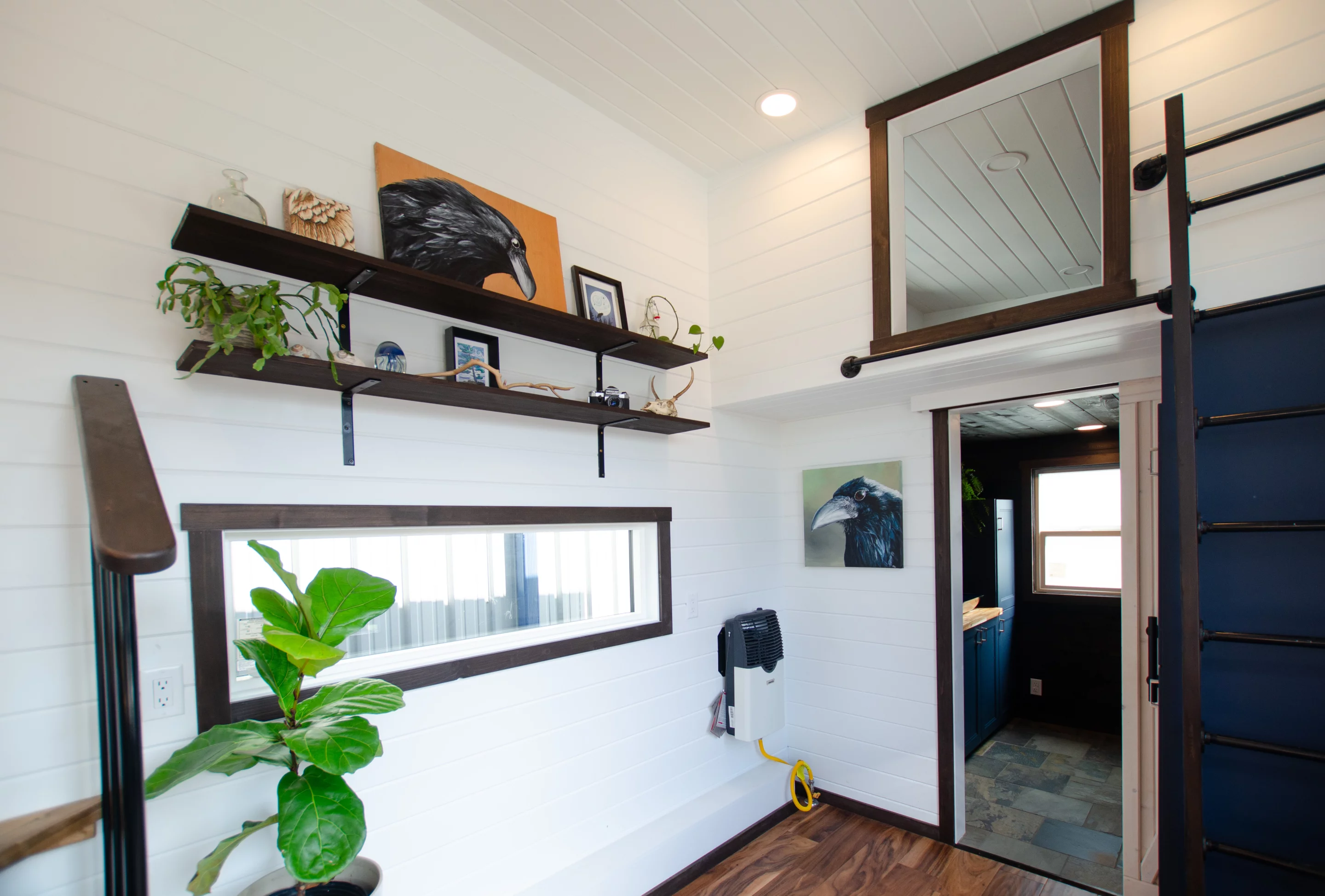 Visitors enter into the Raven's living room, which has space for a sofa, some shelving, and a large cabinet for storage