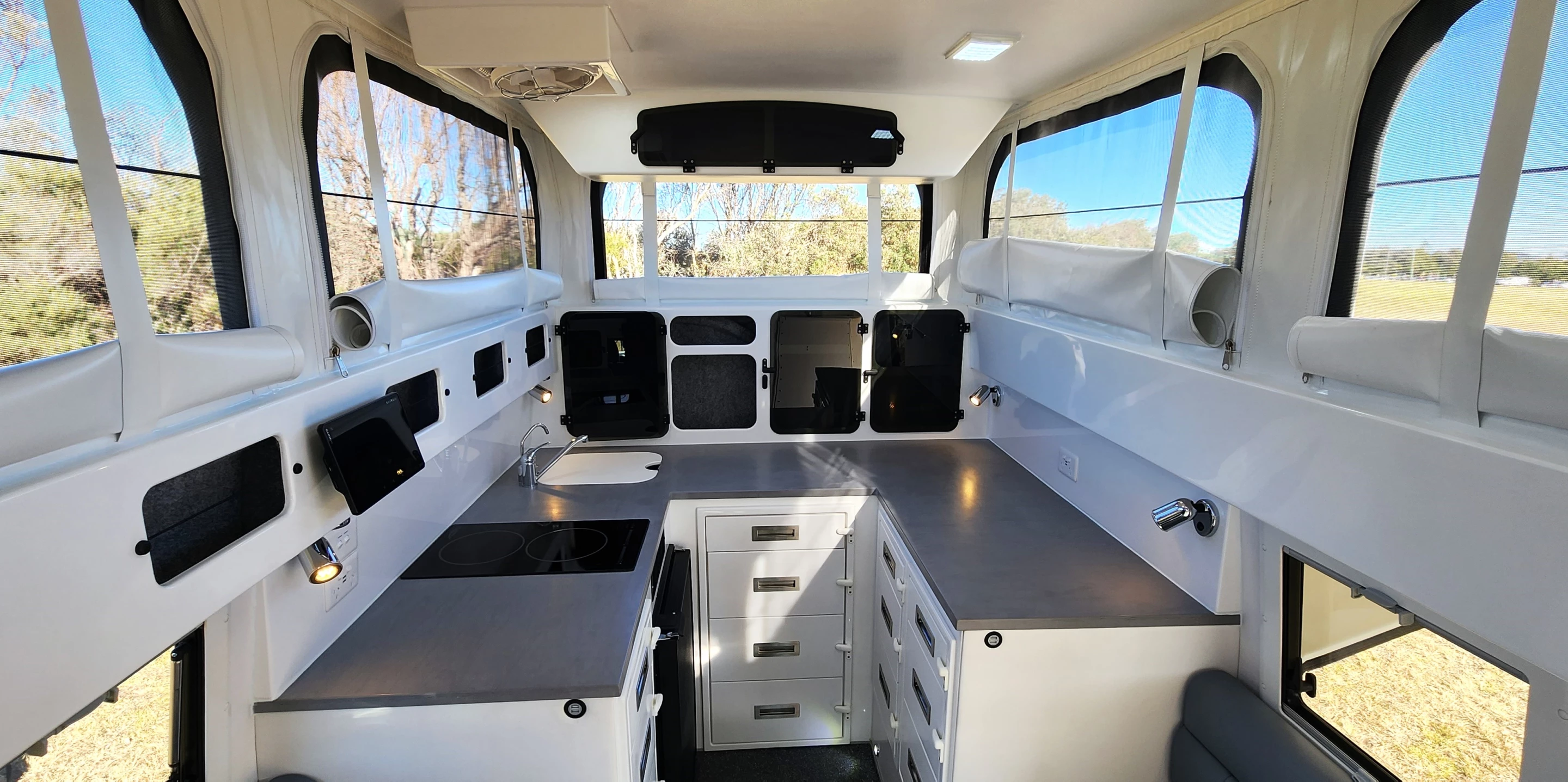 The U-shaped kitchen provides serious countertop space, along with an induction cooktop, sink, microwave and fridge