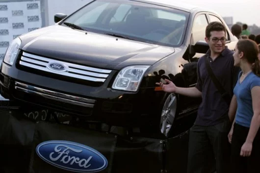 Two friends check out the new 2006 Ford Fusion sedan at the kick off of Fusion Flash Concerts on July 14, 2005 in New York