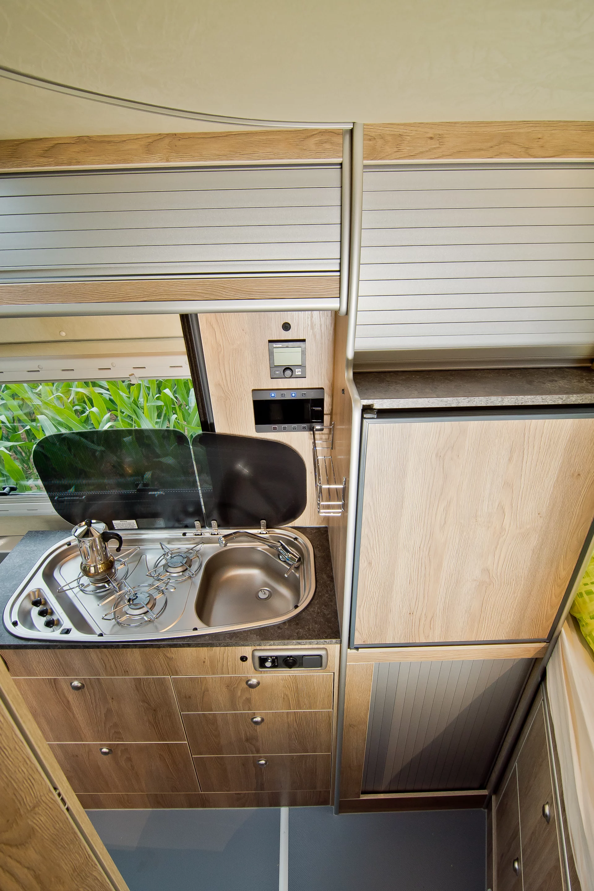 The kitchen includes a standing height fridge/freezer, three-burner stove and sink