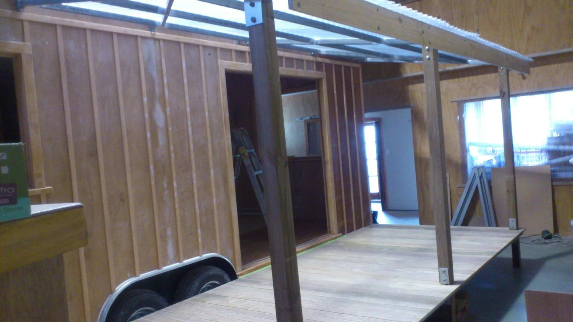 The living room features double glass doors which open out onto a wooden terrace