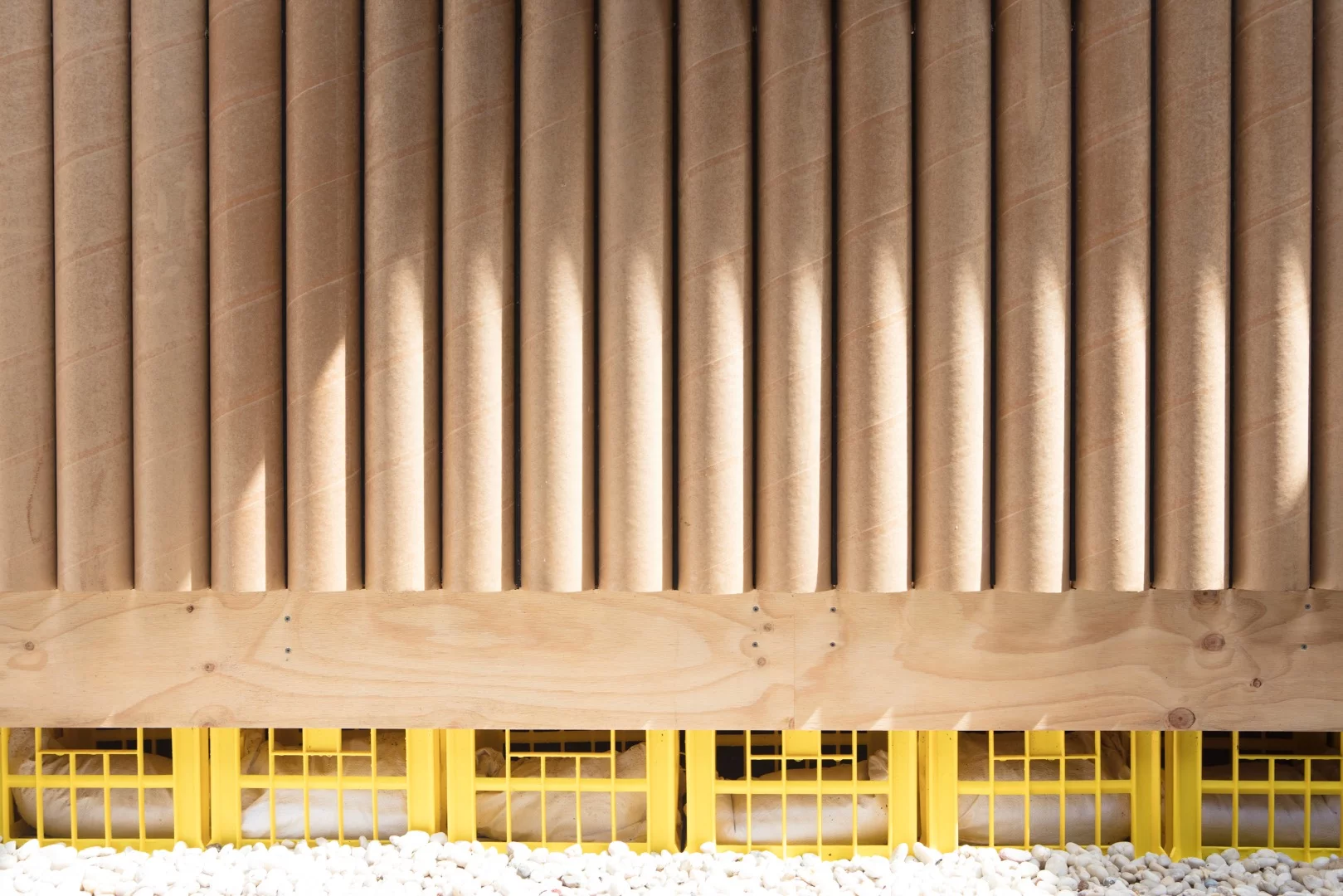 This photo clearly shows the shelter by Shigeru Ban sat atop a foundation of beer crates and sandbags