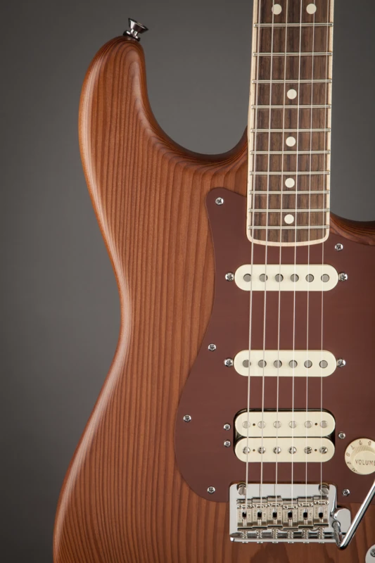The Old Growth Redwood Strat features a brown anodized aluminum pickguard and a HSS pickup configuration