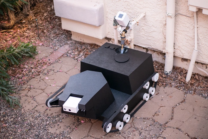 The Yardroid robot refills its water tank at a hose spigot equipped with a special "smart" valve