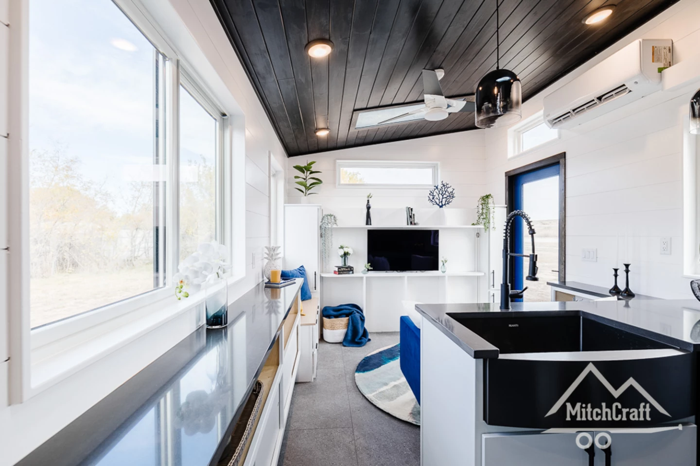 Clay's 34' x 10' Tiny Home features two doors. One offers access to the living room, while the other is on the opposite side of the home and enters into the kitchen
