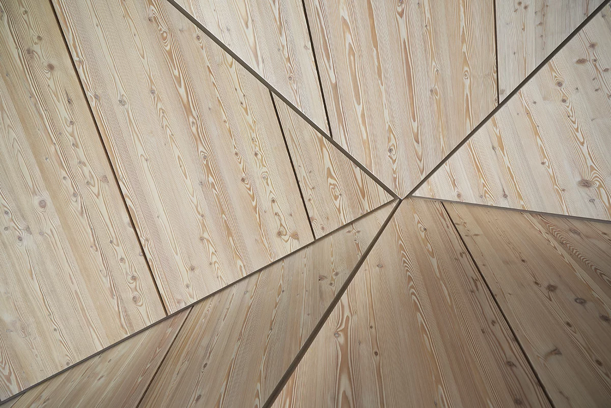 Filled with angular and geometric shapes, the walls and ceilings are clad with wooden panels