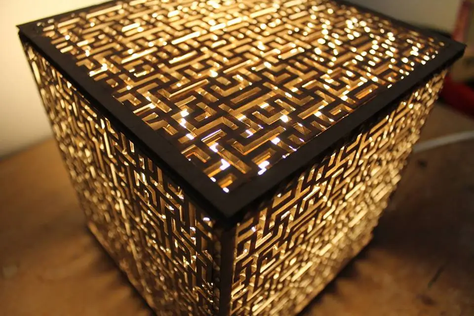 The Golden Cube is a cube-shaped lamp with cardboard cut into intricate maze-like patterns