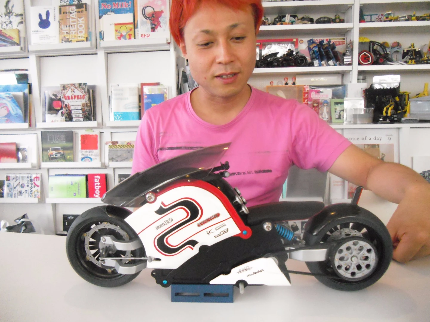 Kota Nezu, the creator of the zec00, seen here in 2013, with the scale model his motorcycle