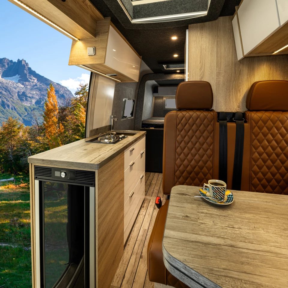The food prep area includes a wooden worktop, dual-burner stove, small sink and fridge