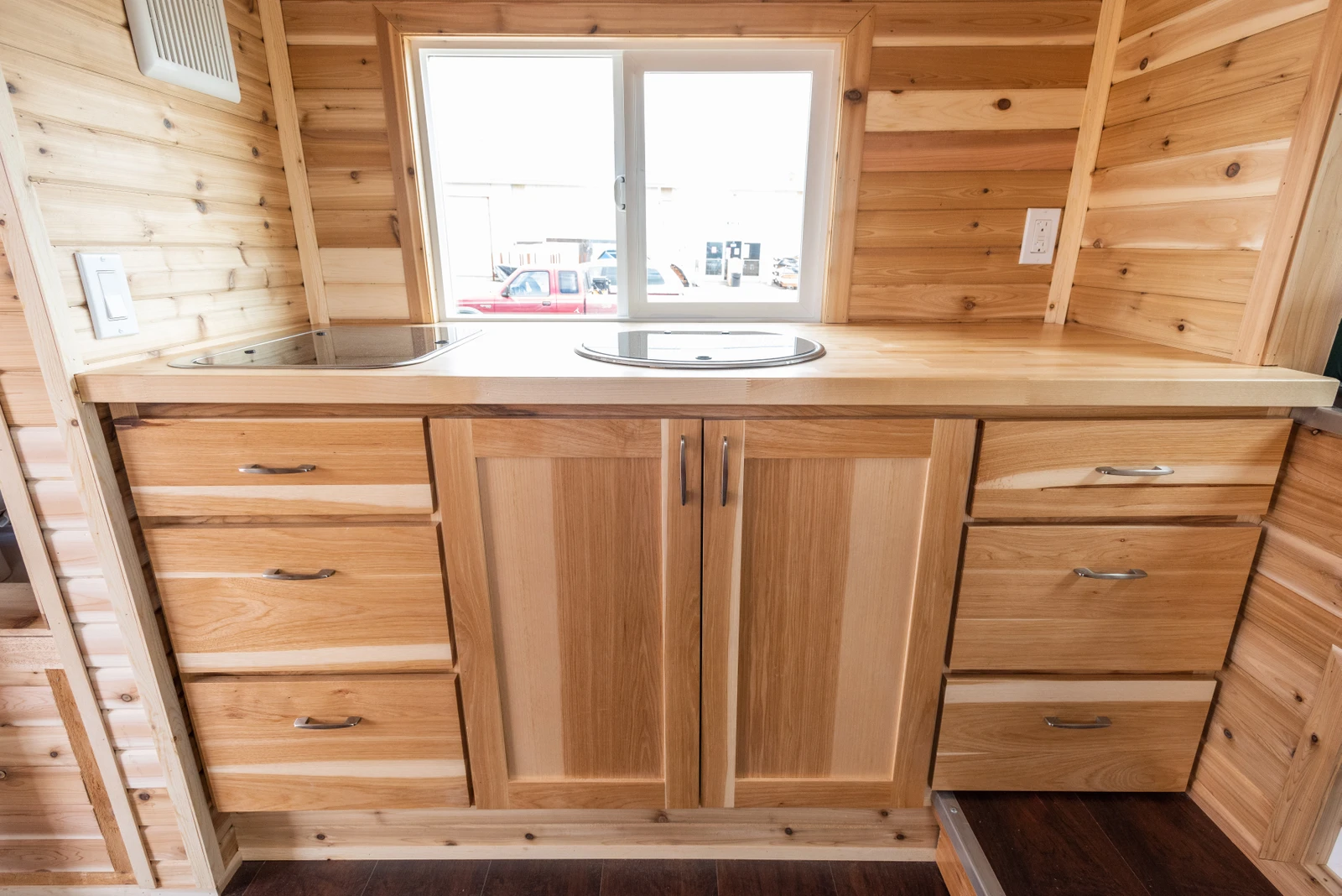 The Tiny Traveler's kitchenette also includes a sink and plywood cabinet space