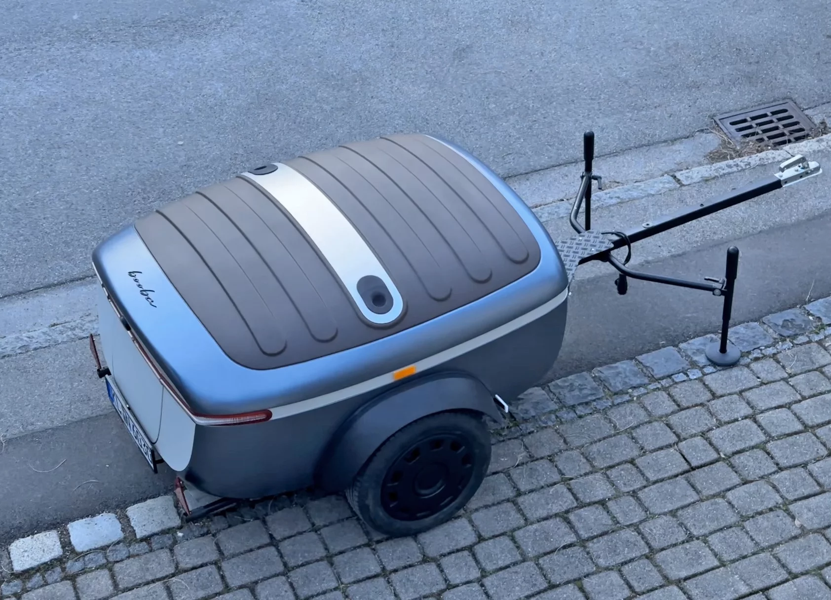 The adjustable support legs on the tow bar hold up the fold-out lid/bed area