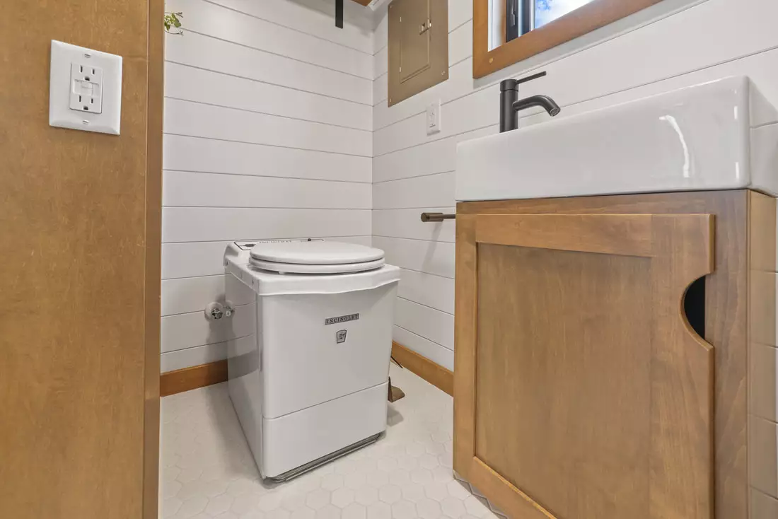 The Coastal Modern's bathroom includes a shower, sink, and incinerating toilet