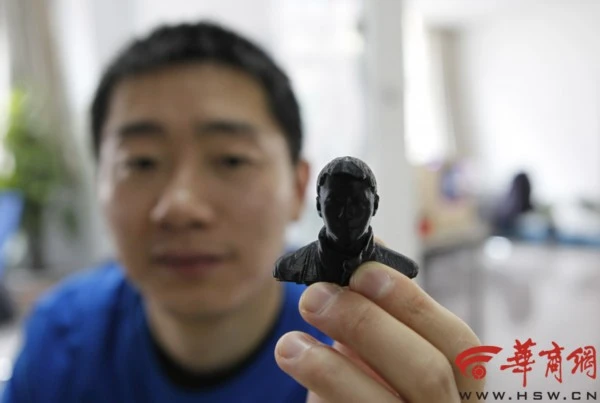 A man holds a personalized bust that was fabricated on a 3D printer in Beijing (Photo: Hinews.cn)