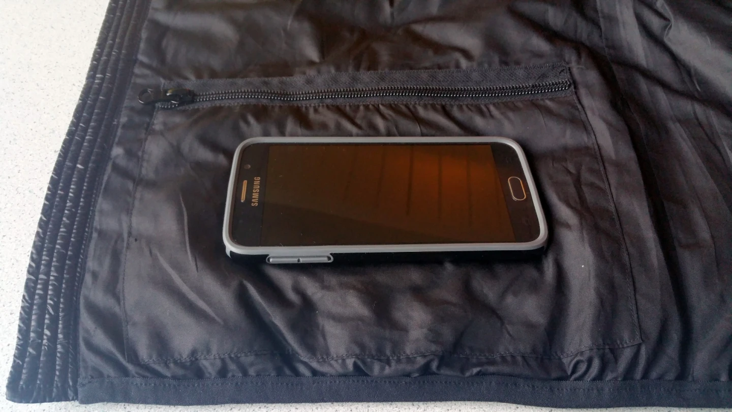 The bottom pocket of the Ravean heated vest, shown with a Samsung Galaxy S6 on top, has ample room for personal belongings