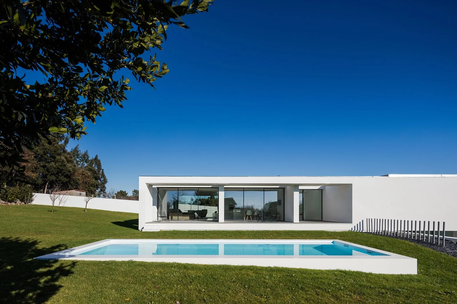 Touguinhó III House, Vila do Conde, Portugal by Raulino Silva Architect. A winner under the "Private Homes" category of the 2018 International Architecture Awards, this home was constructed on what was a planting field and connects its two floors with the garden via a porch and large windows
