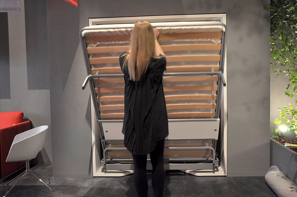The bed features wooden slats and a metal frame which pulls down from the top of the unit