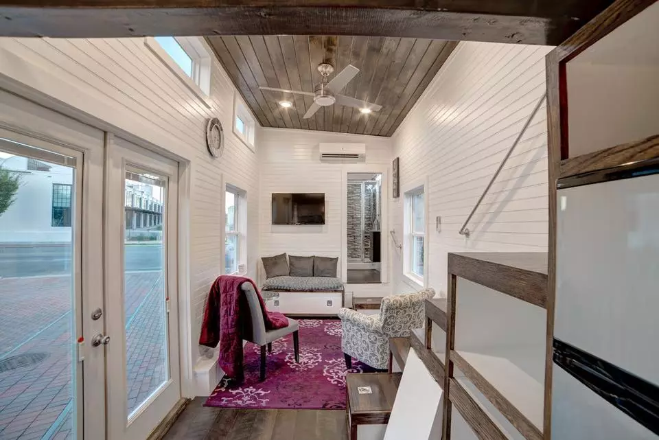 Visitors enter directly into the center of the home, with a lounge area to one side and a kitchen to the other