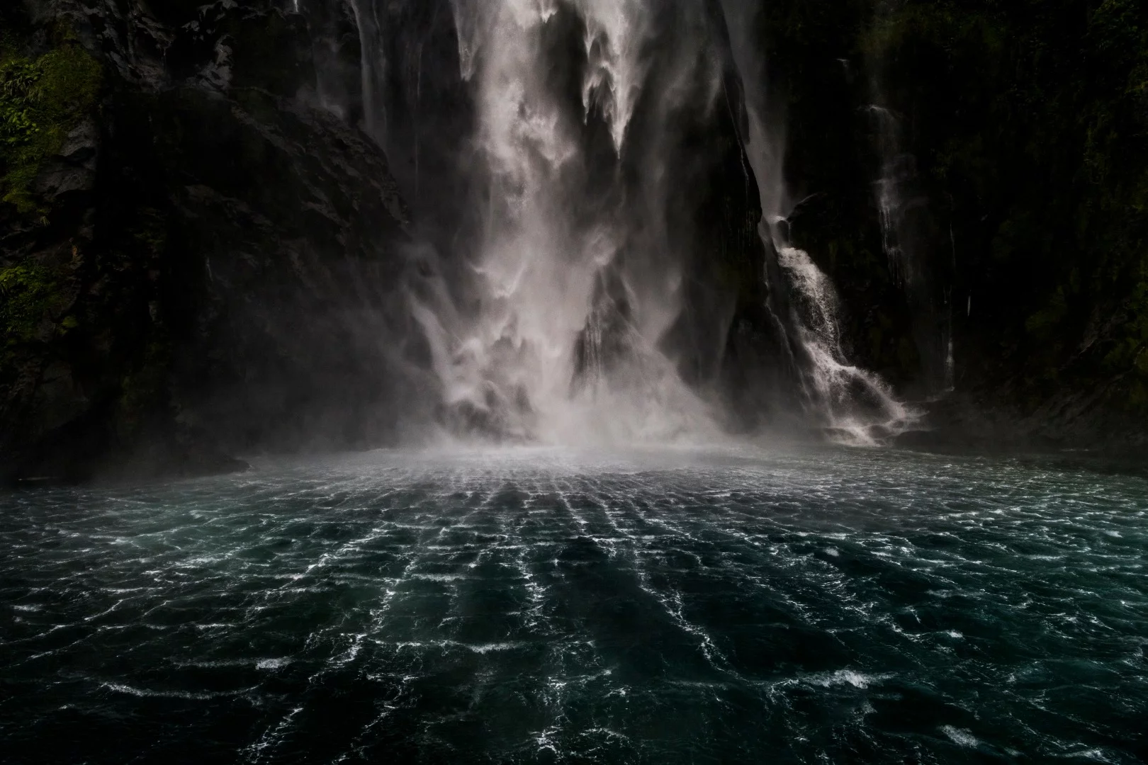 Sterling Falls in the heart of Milford Sound New Zealand. The water falls a staggering 151 m into the basin with such force that it rips across the surface in a beautiful web like texture throwing spray in every direction