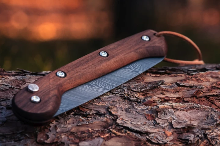 The Woxna Damascus features a push-button lock toward the top of the handle