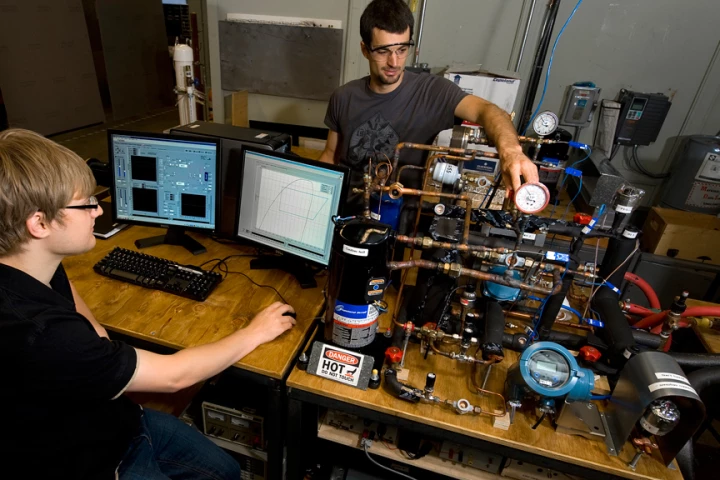 Students, Frederick Welck and Christian Bach, work with an experimental setup for testing valves as part of research led by Purdue University to develop more efficient heat pumps (Image: Purdue University photo/Mark Simons)