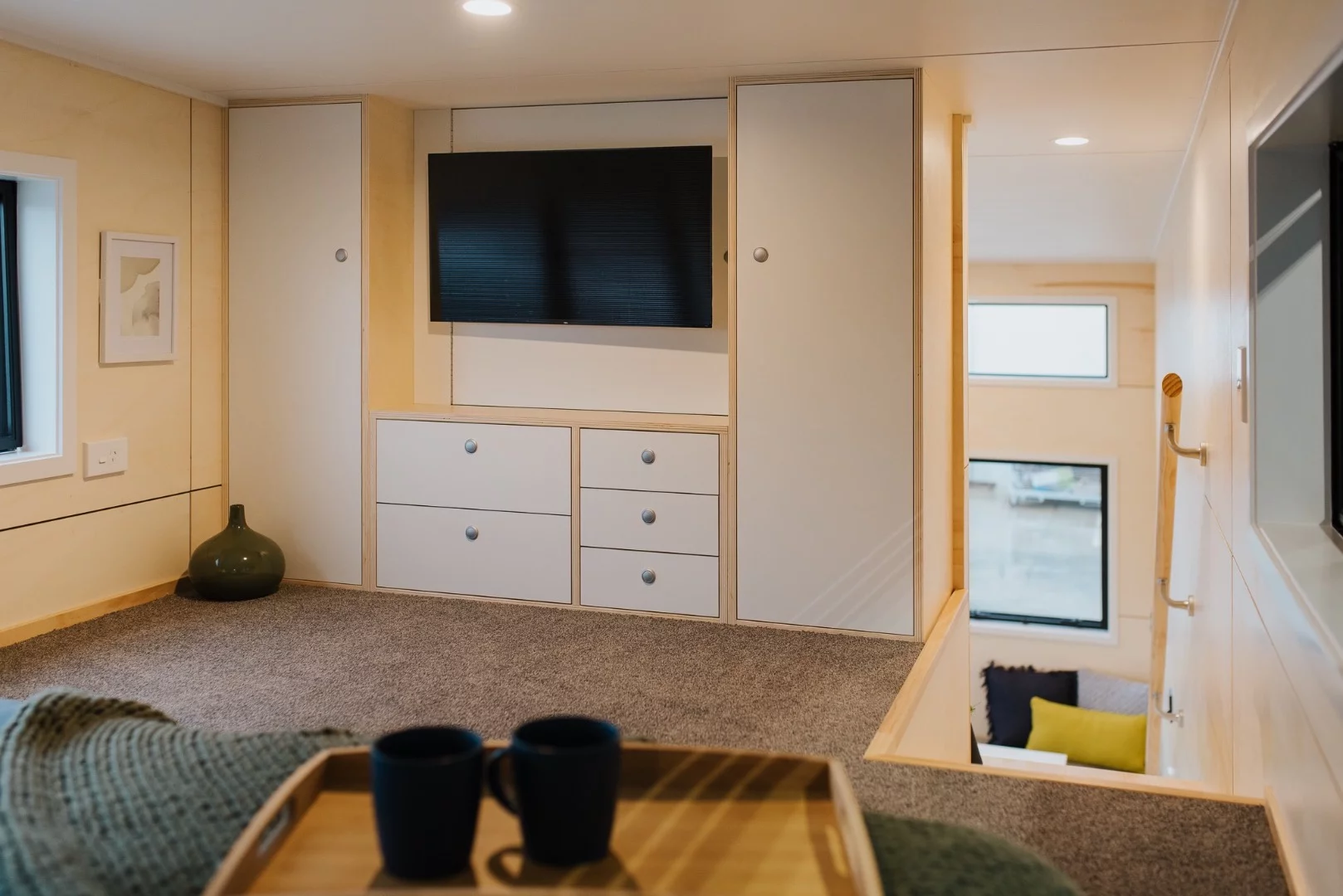 The Green Hill Farm Tiny House's bedroom includes a wall-mounted TV