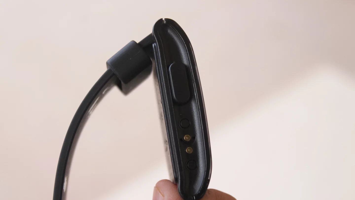 The Pebble's left side features a back button and a charging port