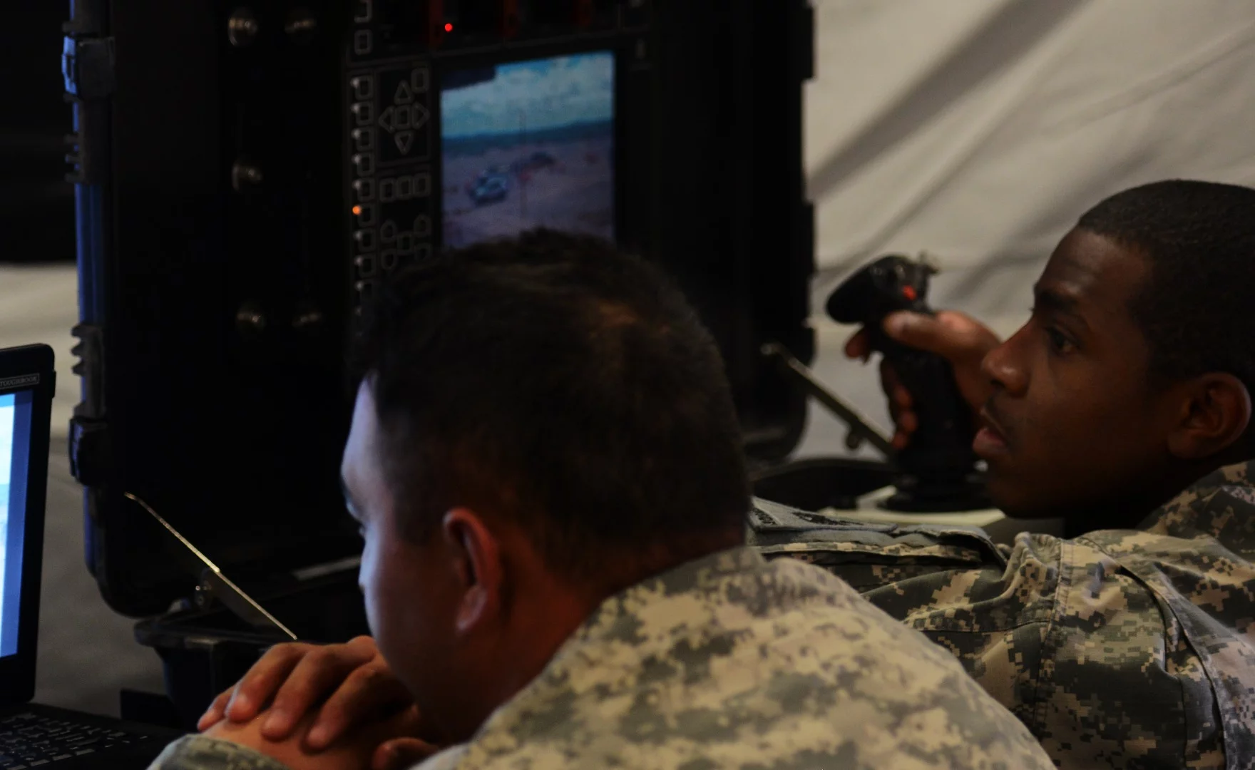 Soldiers inside their tactical operations center remotely control multiple weapons systems on the perimeter