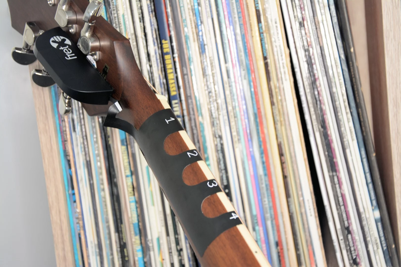 The thin FretX LED sleeve is adhesive-backed and slips under the strings to the front, and is secured in place around back