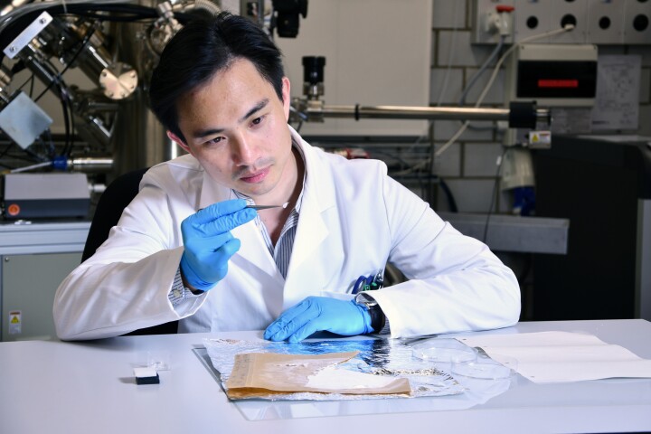 Co-lead scientist Fei Pan examines a piece of the wound dressing material