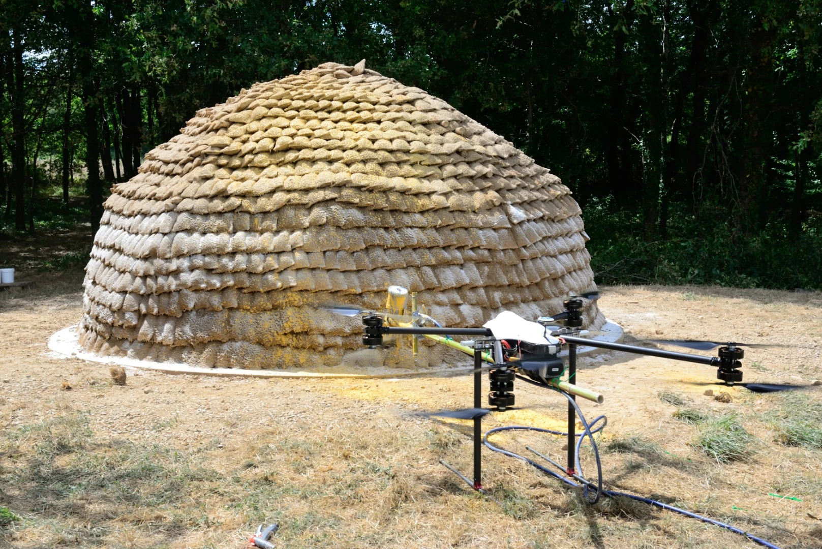 A drone applies the exterior finishing to dome shelter
