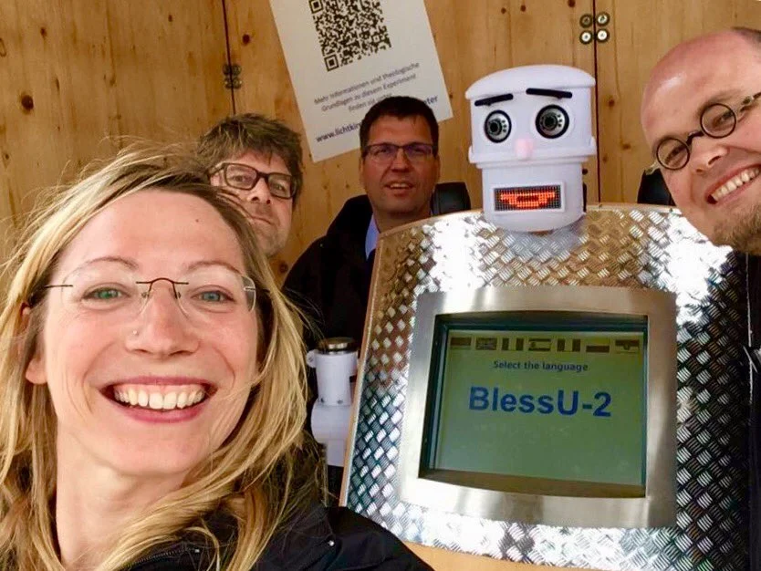 Guests pose in front of the BlessU-2 robot