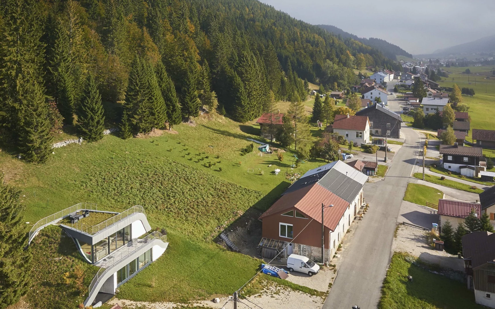 In France sits Casa Jura, a residential home built into the surrounding hill leaving just a couple of small outcrops to allow light in