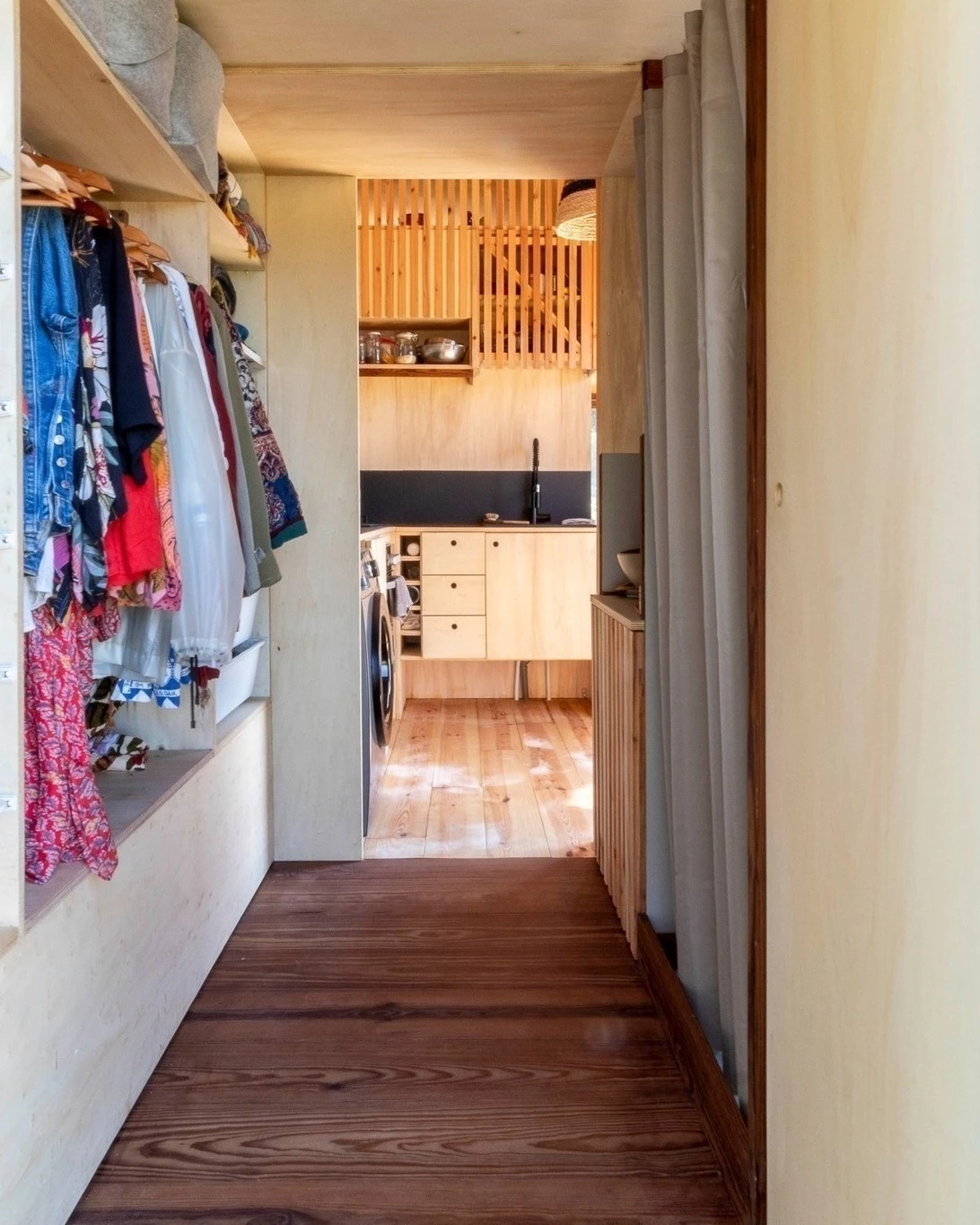 The Baleia's secondary door connects to a hallway space that has storage for clothes and offers access to the bathroom