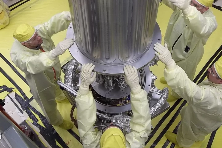 NASA and NNSA engineers lower the wall of the vacuum chamber around the Kilowatt Reactor Using Stirling TechnologY (KRUSTY system)