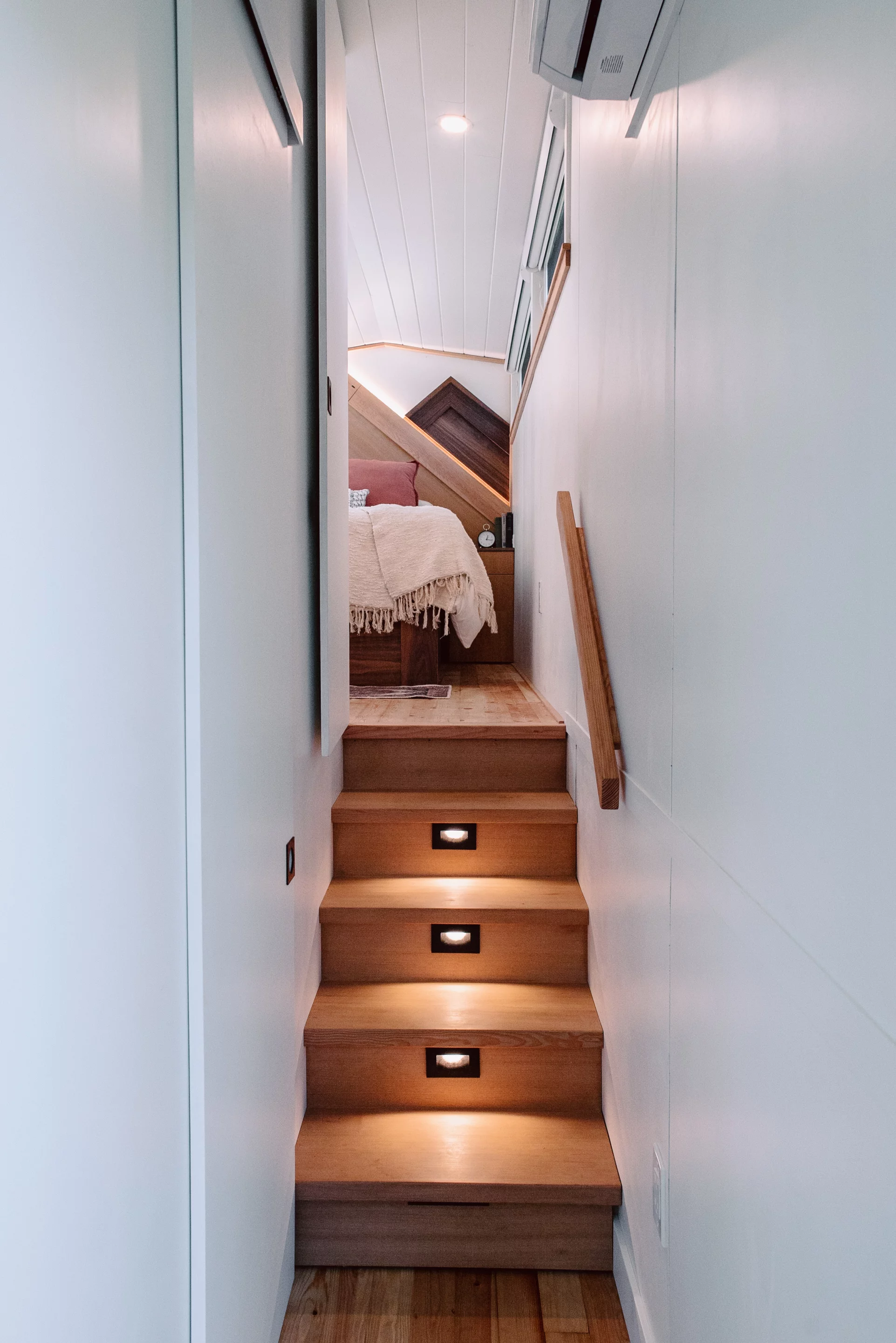 The Macdonald tiny house's bedroom is situated in the raised gooseneck part of the trailer and is accessed by a few steps
