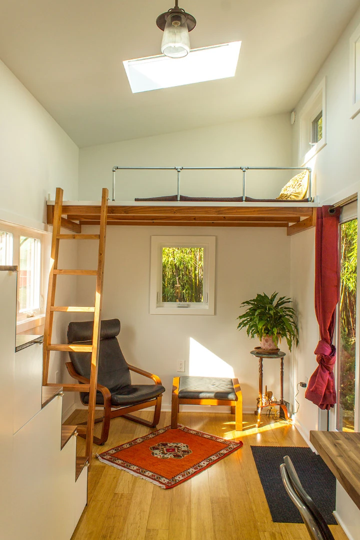 The living room features access to an elevated small loft via a wooden ladder