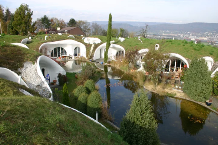 The Earth House Estate Lättenstrasse in Switzerland consists of several Hobbit Hole-style dwellings located around a wet courtyard
