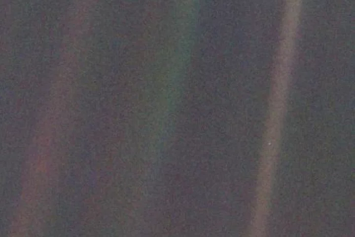 Voyager 1's iconic pale blue dot, with Earth featured as a tiny spec in the light band on the right of the image